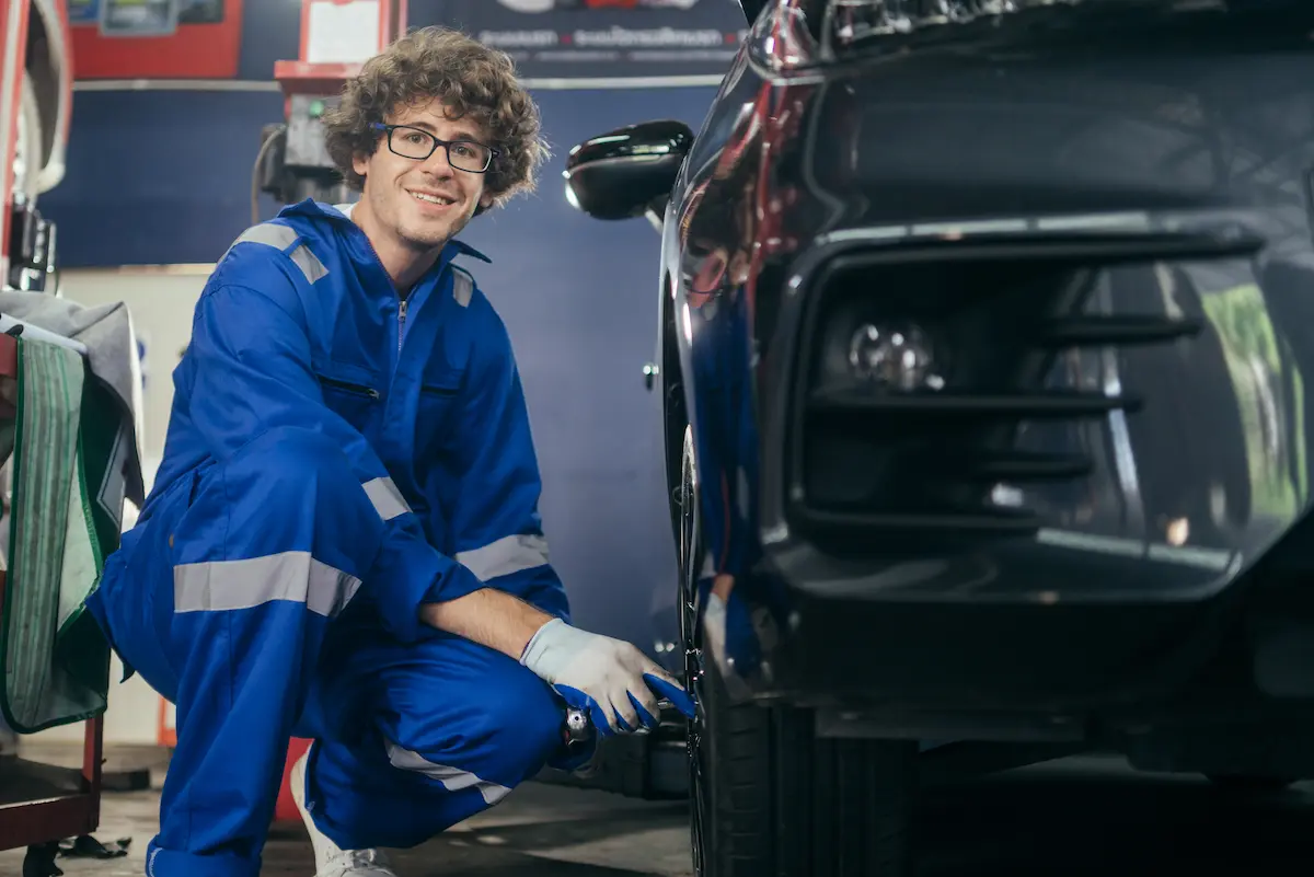 Automotive mechanic working at car tire.